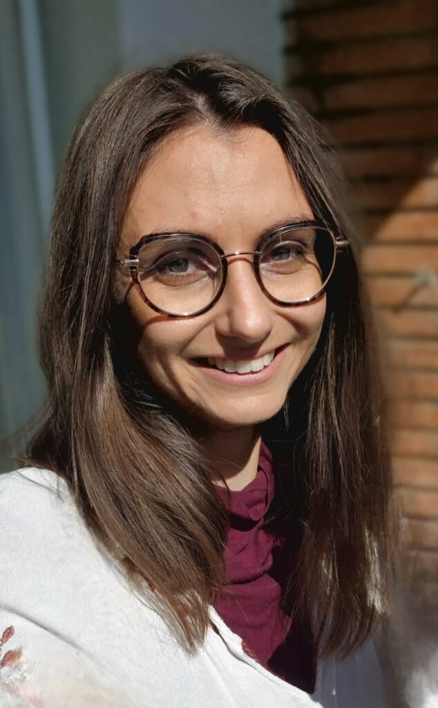 femme yeux clair et cheveux chatain avec des lunettes. A un grand sourire